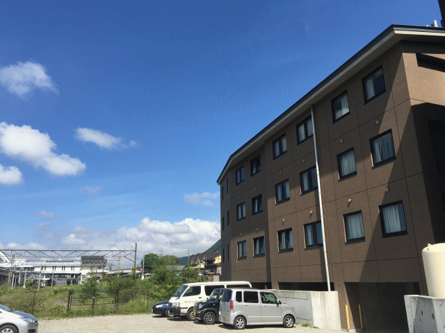 アパホテル＜軽井沢駅前＞軽井沢荘の遠くに、旧軽井沢駅が見える