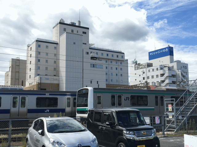 常磐線の線路越しに眺めるグランパークホテルパネックスいわき