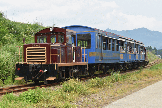 阿蘇白川駅～南阿蘇白川水源駅間の線路に並走する道路からトロッコ列車「ゆうすげ6号」中松行を撮影
